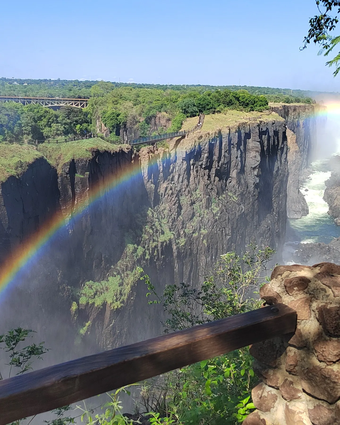A rainbow arcs across the gorge below Victoria Falls